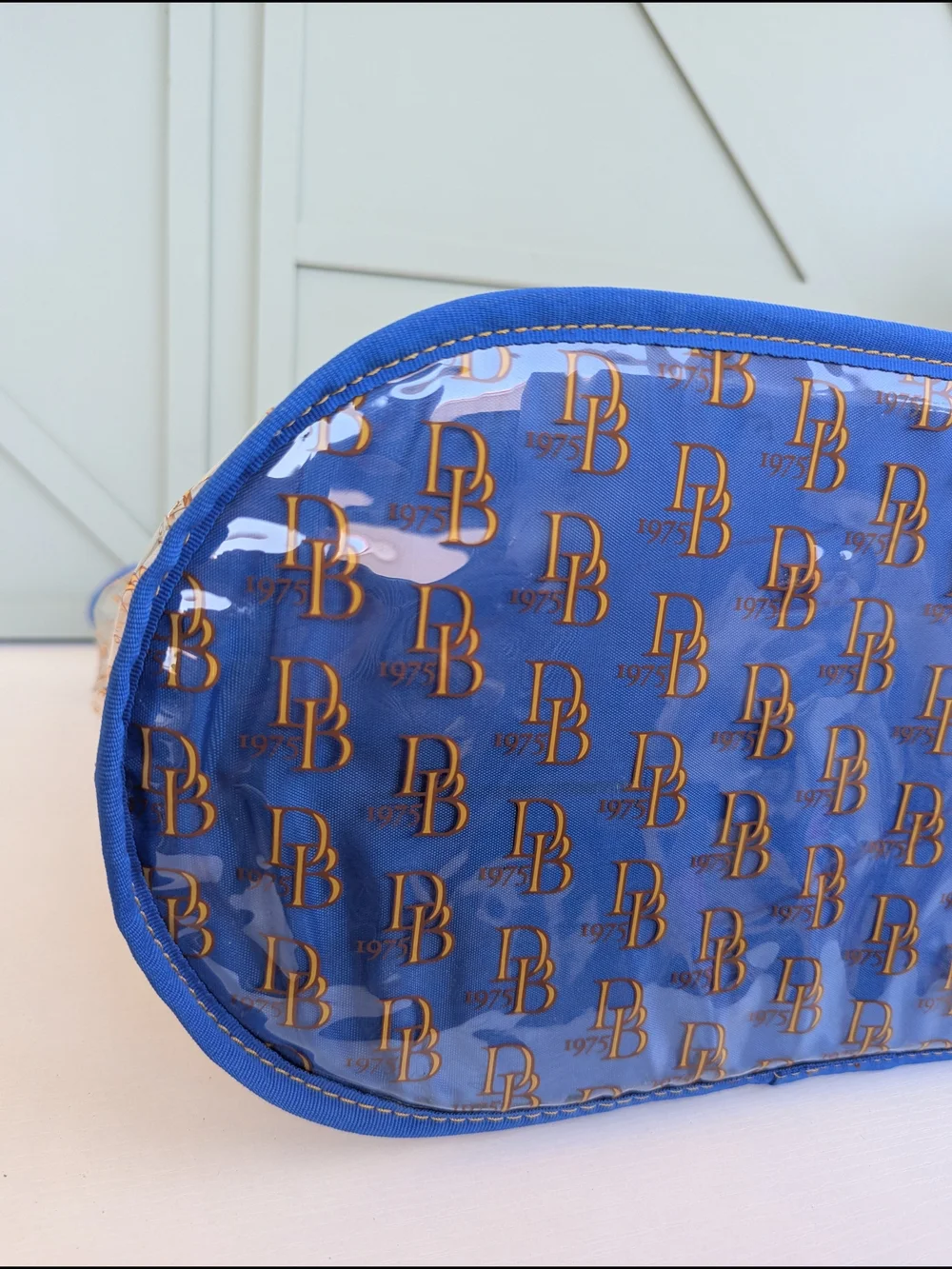 Dooney & Bourke Clear Tote with Blue Trim and Gold Logo Print